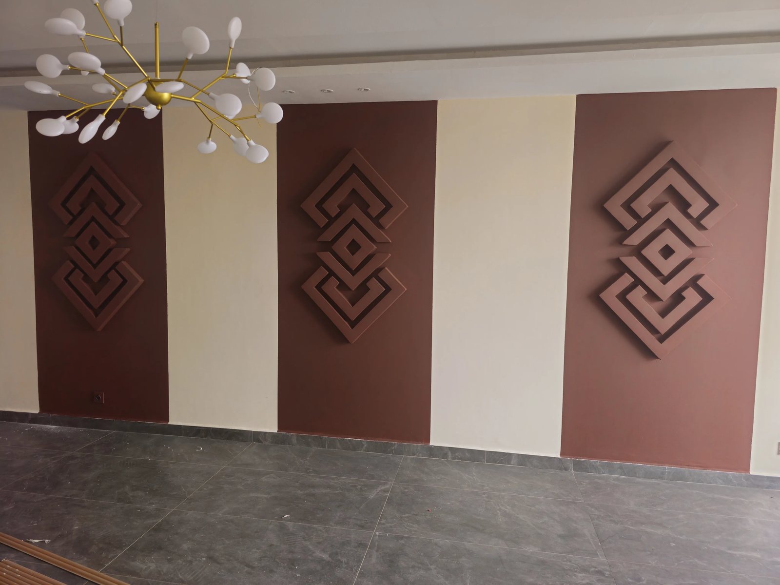 Mur décoratif à motifs géométriques peints en bordeaux et crème