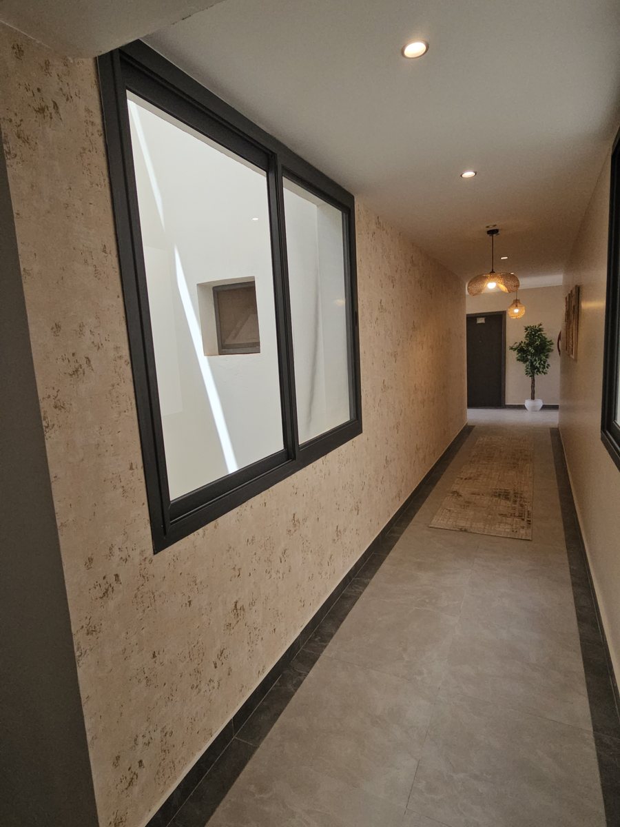 Couloir avec enduit décoratif travertin et éclairage encastré