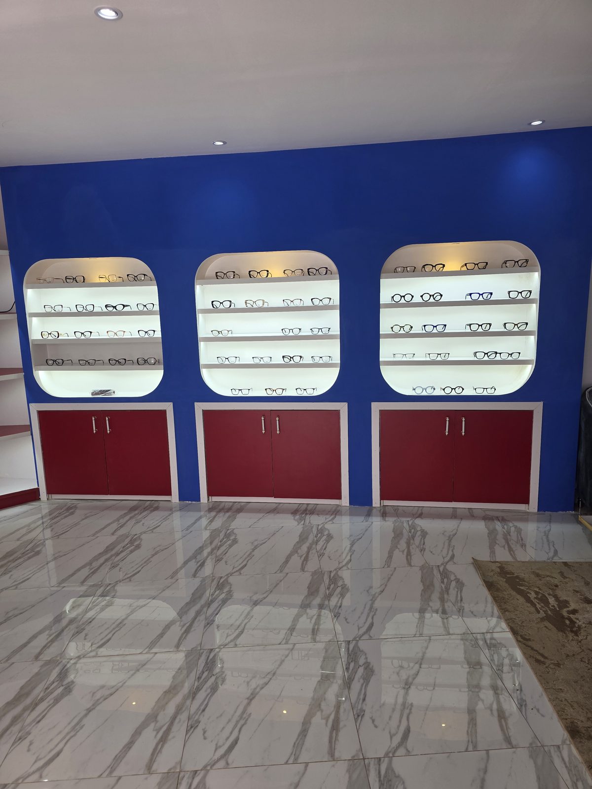 Magasin d'optique : niches murales rétroéclairées et rangements sur mesure