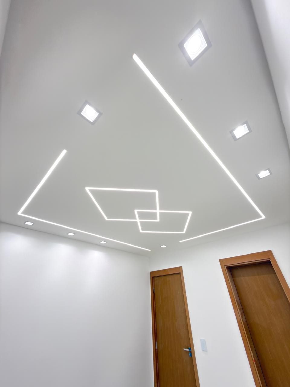 Plafond avec lignes LED encastrées formant un motif géométrique